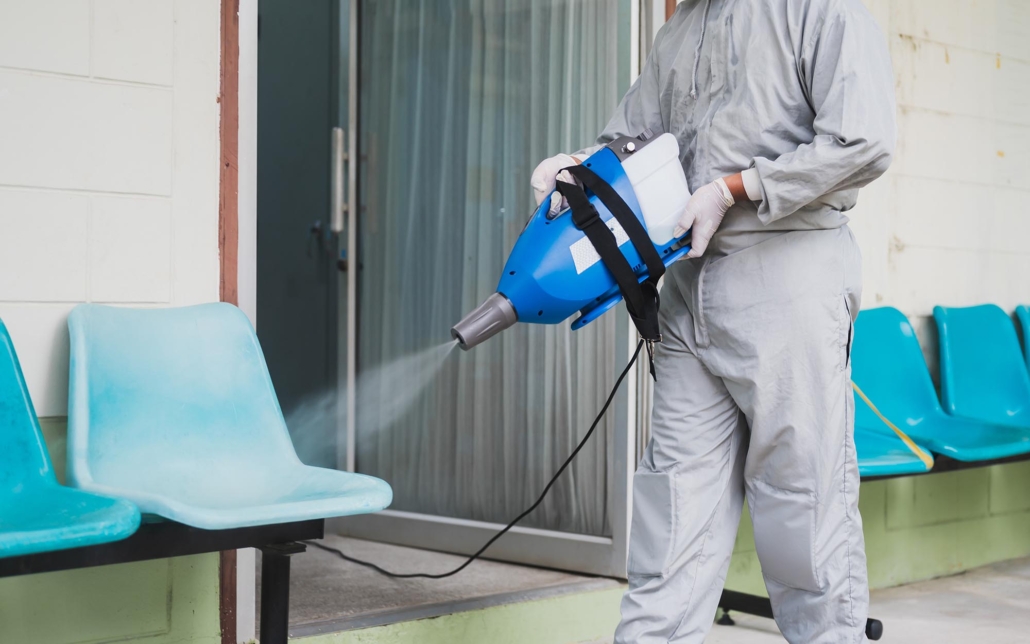 Person disinfecting waiting room with sprayer